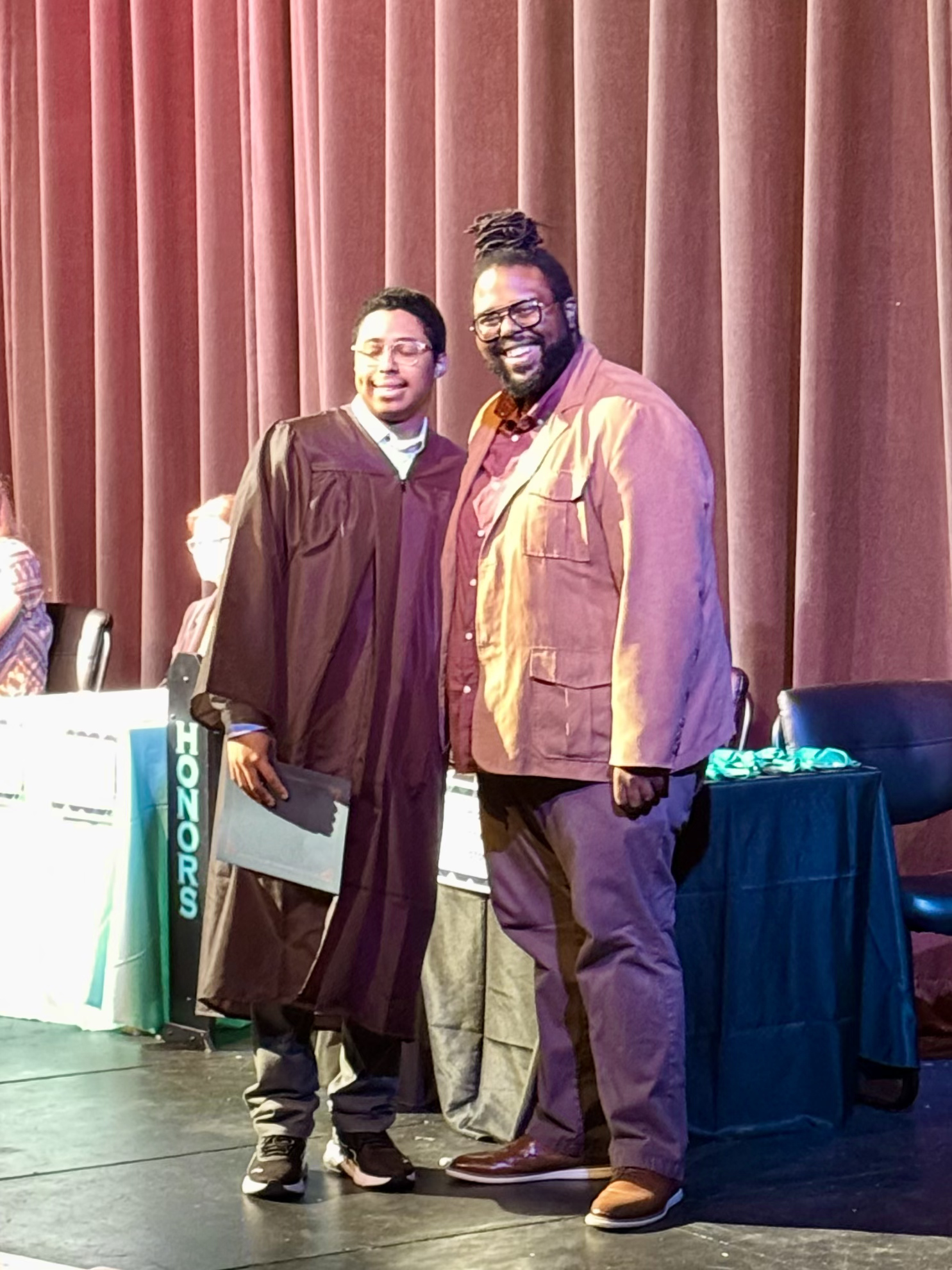Tayn Cabrera Oladeinde, 2026 BABC Scholarship recipient from Century High School standing proudly alongside an instructor at an award ceremony.
